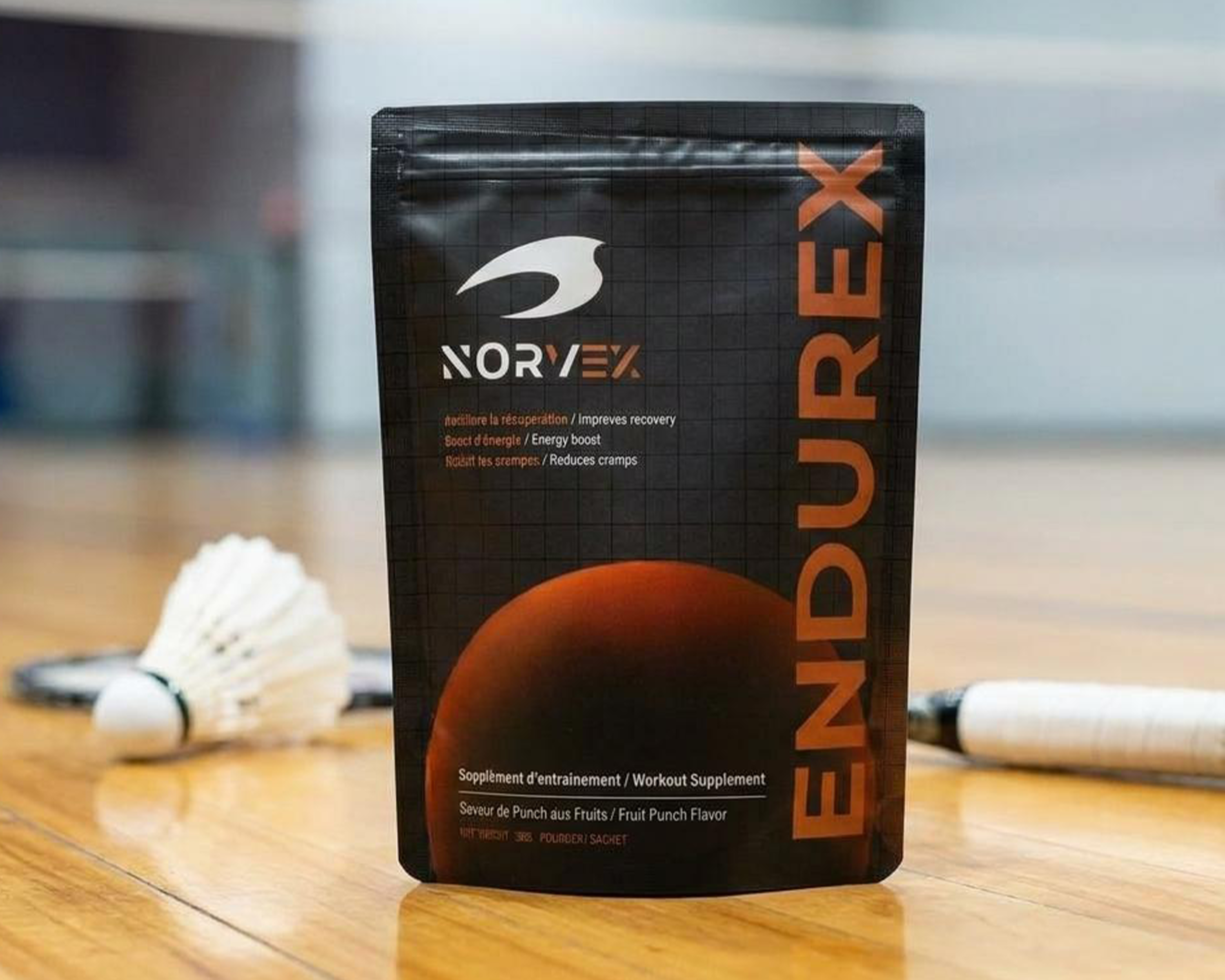Sac Endurex de Norvex posé sur un terrain de badminton avec raquette et volant, supplément de performance pour joueurs de badminton